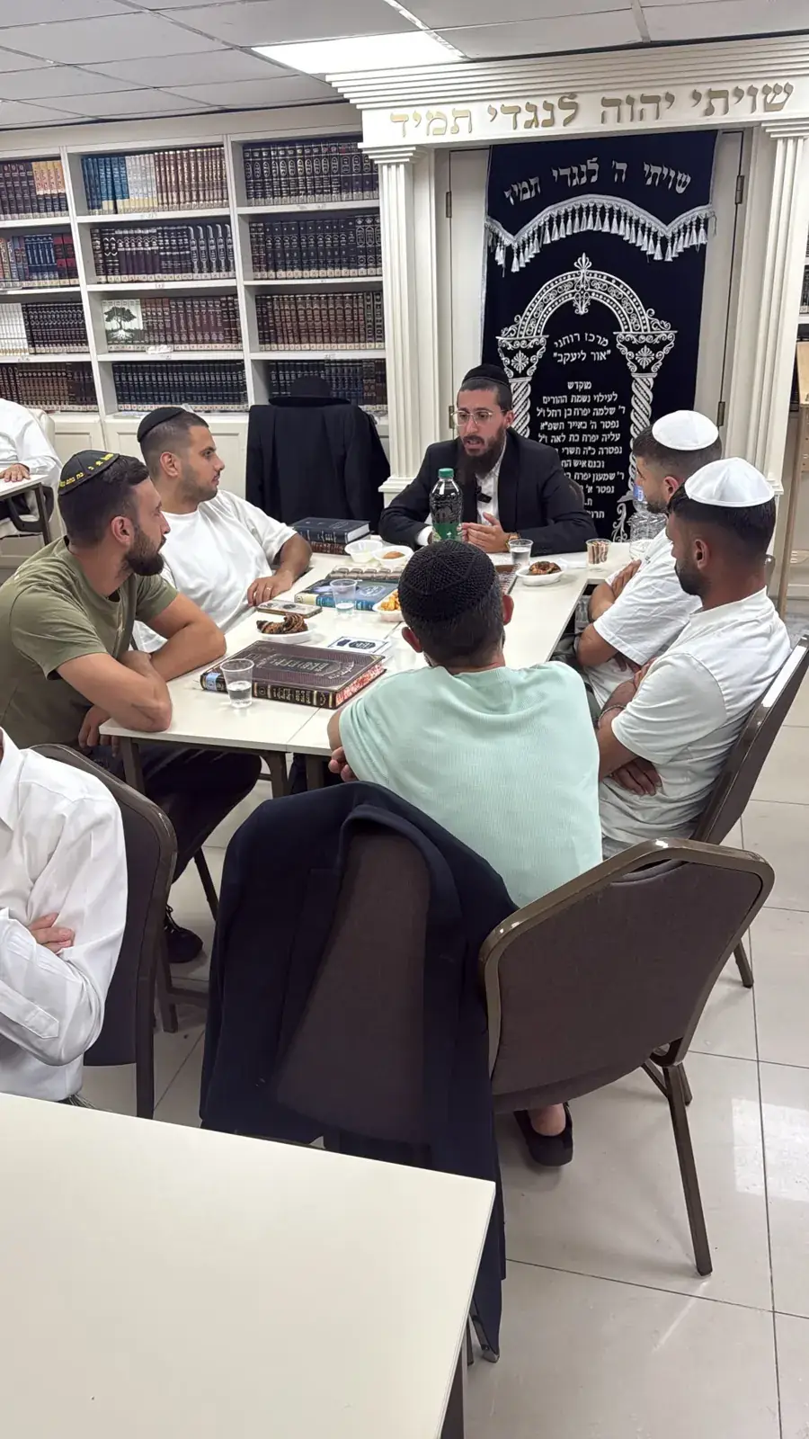 אברך מלמד קבוצת צעירים גמרא בבית המדרש